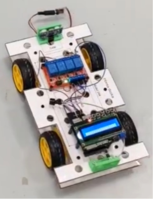 Arduino car prototype with wheels, relay board, ultrasonic sensors, and display